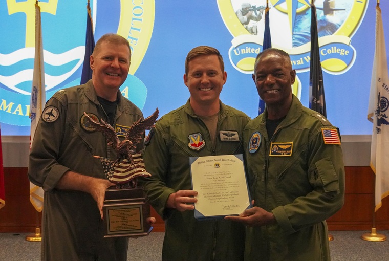 Three men holding awards